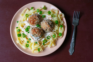 Pasta with meatballs on a dark background
