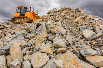 Obraz premium Excavator moving rock in a quarry