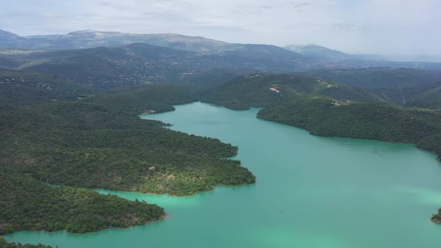 Aerial back traveling discovering a bridge crossing the lake Saint Cassien mountains in background France Var reservoir nautical rowing base 