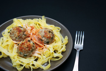 Pasta with meatballs on a dark background