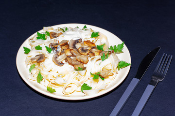Pasta with mushrooms on a dark background.