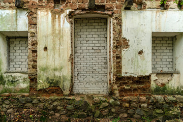 windows and doors of an abandoned house covered with bricks