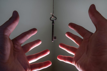 People hands reaching for vintage key hanging on a string. Busin