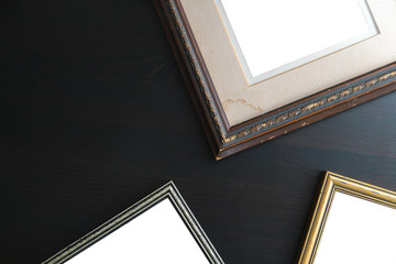 Fototapeta premium Blank empty frames on dark wooden background. Art gallery, museu
