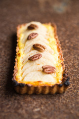 Pear tart with  pecan nuts  and custard cream, top view, flat lay , vertical composition