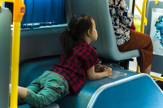 A Child Lays On The Seat In The Shaking Bus. Alone.