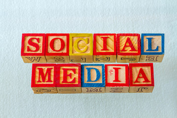 The term social media visually displayed using colorful wooden blocks on a clear background image...