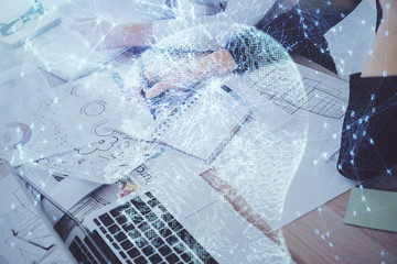 Double exposure of woman's writing hand on background with brain hud. Concept of learning.