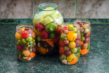 Jars of pickled vegetables. Traditional marinated food - tomatoe