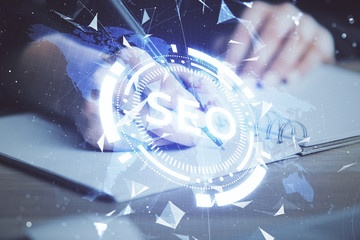 Multi exposure of woman's hands making notes with SEO icon. Concept of Search engine optimization