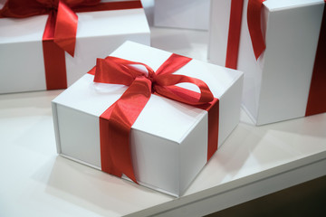 Christmas or birthday time. Gift boxes with red ribbons on woode