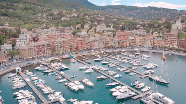 Aerial shot. Santa Margherita Ligure is a beautiful resort town on the Ligurian coast in Italy. View from the bay, in the frame of the yacht and the city pier, with beautiful houses.