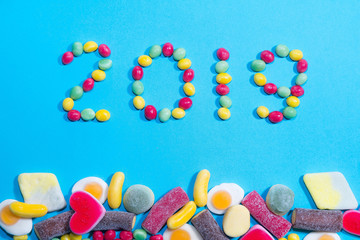 New years 2019. Pile of delicious colorful chewing candies backg
