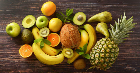 Healthy fruits, foods background. Different fruits over wooden background. Banner.