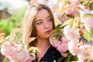 Naklejka premium Spring in my head. blossom smell, allergy. girl in cherry flower. Sakura tree blooming. natural summer beauty. skincare and spa. Natural cosmetics for skin. woman in spring flower bloom