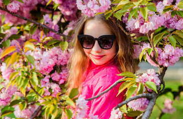 Enjoy smell of tender bloom. Sakura flower concept. Gorgeous flower and female beauty. Girl cherry flower background. Sakura tree blooming. Park and garden. Small girl child in spring flower bloom