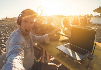 Youtuber taking selfie during video live streaming at chiringuito beach party - Man vlogger using...