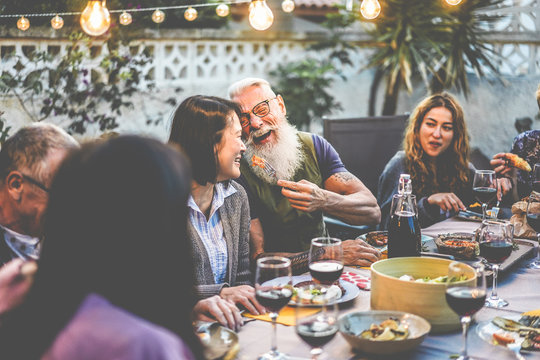 Happy Family People Having Fun At Barbecue Dinner - Multiracial Friends Eating At Bbq Meal - Food, Friendship, Relationship And Summer Lifestyle Concept - Focus On Hipster Man Face