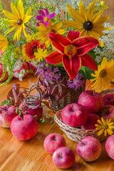 Still life with apples and flowers. Summer or autumn. Yellow flowers and red apples
