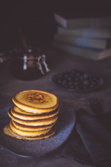 American Pancakes with Organic Berries and Maple Syrup on Dark Background. Classic Homemade Breakfast.