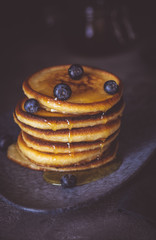 American Pancakes with Organic Berries and Maple Syrup on Dark Background. Classic Homemade Breakfast.
