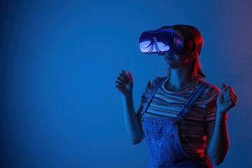 The game vr.The girl in the helmet and with the controller plays a game with creative light.