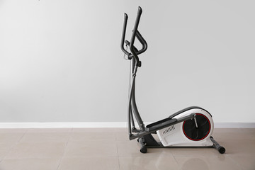 Modern exercise machine near light wall