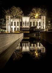 Mystic city hall of Tilburg at night with reflection in the wate