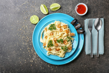 Plate with tasty shrimps and pasta on table