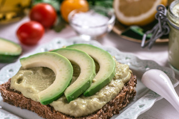 Organic Guacamole Avocado Spread and Slices with Fresh Cherry Tomato and Black Sesame. Healthy Diet Breakfast Concept.