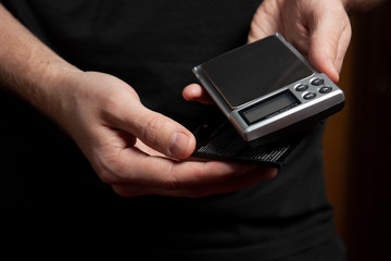 man holds in his hands digital electronic scale