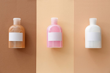 Bottles of shampoo on color background