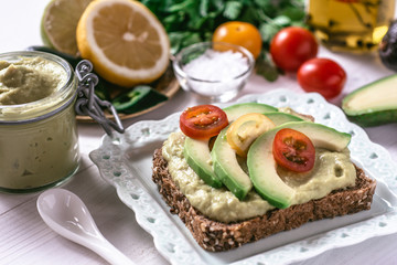 Organic Guacamole Avocado Spread and Slices with Fresh Cherry Tomato and Black Sesame. Healthy Diet Breakfast Concept.