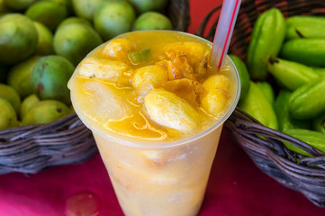 Fresh Brazilian caipirinha cocktail made with local siriguela fruit at a beach bar shack in Bahia,...