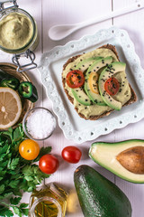 Organic Guacamole Avocado Spread and Slices with Fresh Cherry Tomato and Black Sesame. Healthy Diet Breakfast Concept.