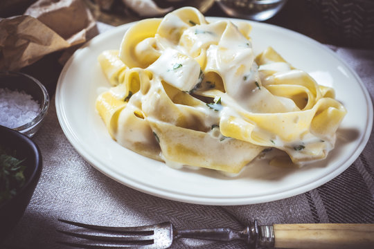Traditional Italian Alfredo Pasta Plate with Creamy Cheese and Basil Sauce