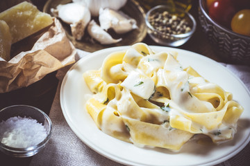 Traditional Italian Alfredo Pasta Plate with Creamy Cheese and Basil Sauce
