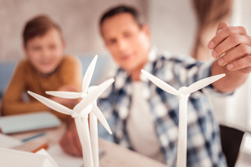 Loving father showing his son model of ecological windmill