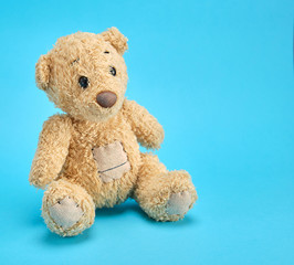 old brown teddy bear on a blue  background