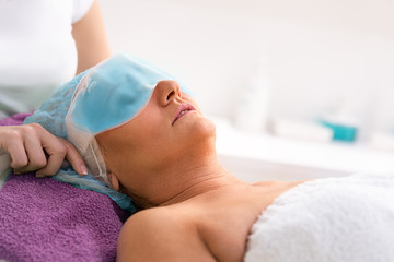 Woman with blue gel mask on her eyes