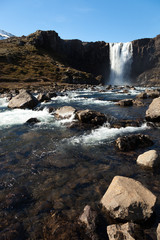 Clean water of famous Iceland waterfalls on a stony rocky mountain landscape