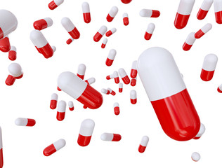 Red and white pill capsules on a white background..