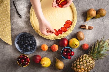 Female Hands Prepare Tart Pie with Fresh Dough and Colorful Fruits