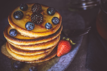 Fresh Pancakes with Organic Maple Syrup and Berries on Dark Background