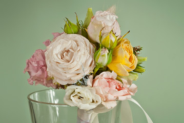 A small bouquet of flowers on a green background. Wedding bouquet for the groom.