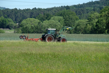 Obraz premium Landwirt beim Rechen im Altmühltal