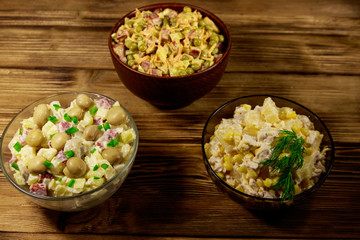 Set of festive mayonnaise salads on wooden table