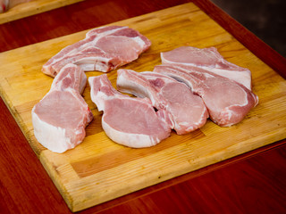 Slices of raw steak on a wooden board. Preparation for frying.