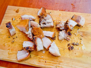 Pieces of fried bacon on a wooden board.