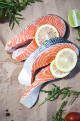 Salmon. Raw Trout Red Fish Steak served with Herbs and Lemon. Cooking Salmon, sea food. Healthy eating concept